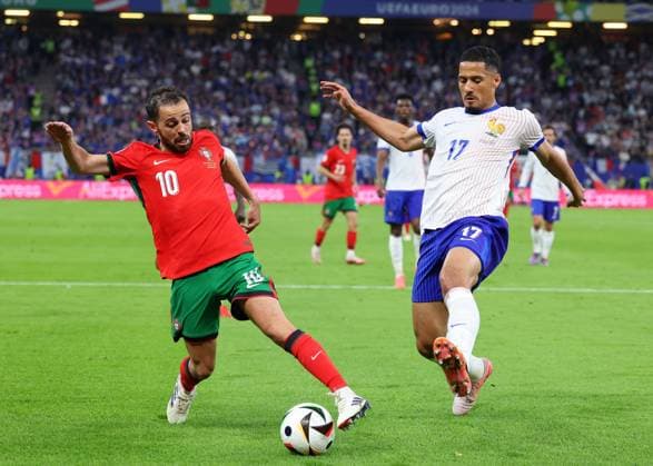Hamburg, Germany, 5th July 2024. Bernardo Silva of Portugal tussles with William Saliba of France during the UEFA European Championships Quarter Final match at Volksparkstadion, Hamburg. Picture credit should read: Paul Terry Sportimage EDITORIAL USE ONLY. No use with unauthorised audio, video, data, fixture lists, club league logos or live services. Online in-match use limited to 120 images, no video emulation. No use in betting, games or single club league player publications. SPI-3217-0036