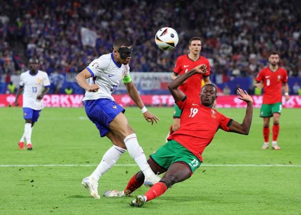 Hamburg, Germany, 5th July 2024. Nuno Mendes of Portugal blocks a shot from Kylan Mbappe of France during the UEFA European Championships Quarter Final match at Volksparkstadion, Hamburg. Picture credit should read: Paul Terry Sportimage EDITORIAL USE ONLY. No use with unauthorised audio, video, data, fixture lists, club league logos or live services. Online in-match use limited to 120 images, no video emulation. No use in betting, games or single club league player publications. SPI-3217-0045