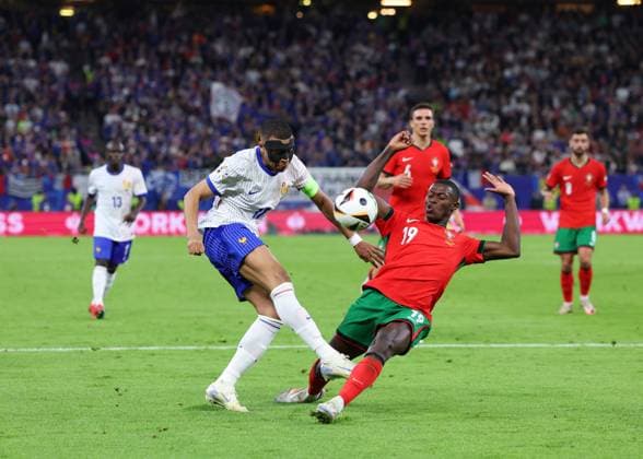 Hamburg, Germany, 5th July 2024. Nuno Mendes of Portugal blocks a shot from Kylan Mbappe of France during the UEFA European Championships Quarter Final match at Volksparkstadion, Hamburg. Picture credit should read: Paul Terry Sportimage EDITORIAL USE ONLY. No use with unauthorised audio, video, data, fixture lists, club league logos or live services. Online in-match use limited to 120 images, no video emulation. No use in betting, games or single club league player publications. SPI-3217-0046