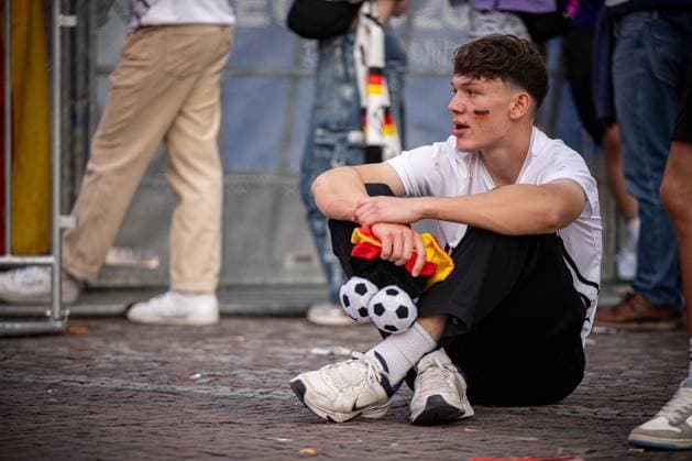 A Germany fan sits depressed on the ground in front of the screen of the fan festival Fans of the German national team lie in tears after the match against Spain and the elimination from the EURO2024 at the fan festival with public viewing on the Stuttgart Schlossplatz Stuttgart, EURO2024 Fanfest Schlossplatz, 05 07 2024 Stuttgart Copyright: xDennisxDuddek xEibnerxPressefotox EP_DDK