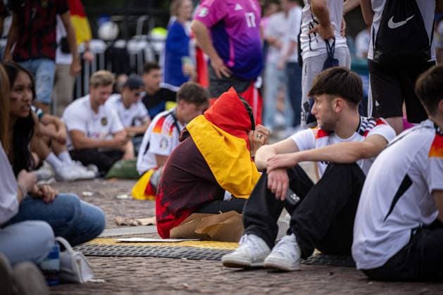 A Germany fan sits depressed on the ground in front of the screen of the fan festival Fans of the German national team lie in tears after the match against Spain and the elimination from the EURO2024 at the fan festival with public viewing on the Stuttgart Schlossplatz Stuttgart, EURO2024 Fanfest Schlossplatz, 05 07 2024 Stuttgart Copyright: xDennisxDuddek xEibnerxPressefotox EP_DDK