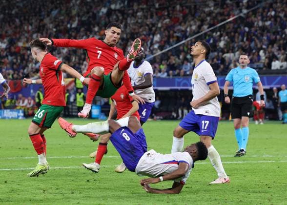 Hamburg, Germany, 5th July 2024. Cristiano Ronaldo of Portugal tussles with Aurelien Tchouameni of France during the UEFA European Championships Quarter Final match at Volksparkstadion, Hamburg. Picture credit should read: Paul Terry Sportimage EDITORIAL USE ONLY. No use with unauthorised audio, video, data, fixture lists, club league logos or live services. Online in-match use limited to 120 images, no video emulation. No use in betting, games or single club league player publications. SPI-3217-0056