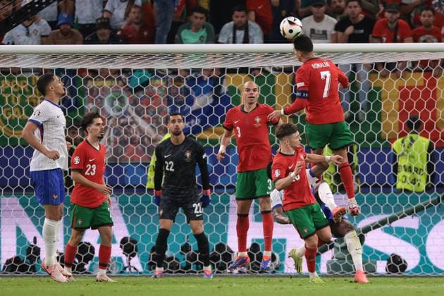 Hamburg, Germany, 5th July 2024. Cristiano Ronaldo of Portugal clashes with Aurelien Tchouameni of France as he heads the ball away during the UEFA European Championships quarter final match at Volksparkstadion, Hamburg. Picture credit should read: Jonathan Moscrop Sportimage EDITORIAL USE ONLY. No use with unauthorised audio, video, data, fixture lists, club league logos or live services. Online in-match use limited to 120 images, no video emulation. No use in betting, games or single club league player publications. SPI-3219-0139