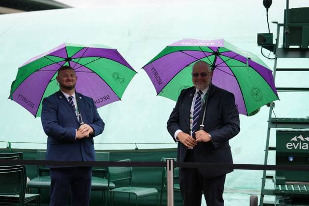 Lawn Tennis - 2024 Wimbledon Championship Mens singles Cameron Norrie GBR) v Alexander Zverev (GER) All England Lawn Tennis & Croquet Club - Saturday 6th July 2024 Rain delays with Umbrellas security guards with empty court 