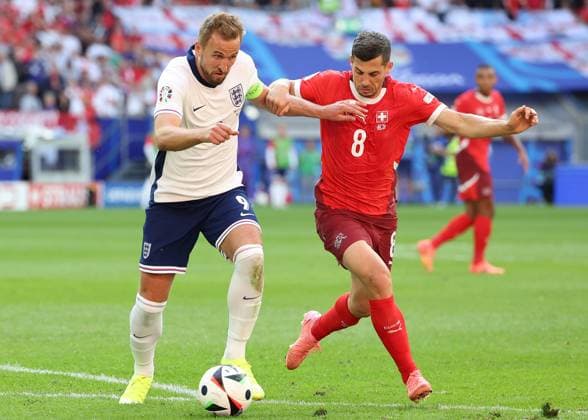 Dusseldorf, Germany, 6th July 2024. Harry Kane of England and Remo Freuler of Switzerland challenge for the ball during the UEFA European Championships Quarter Final match at Dusseldorf Arena, Dusseldorf. Picture credit should read: Paul Terry Sportimage EDITORIAL USE ONLY. No use with unauthorised audio, video, data, fixture lists, club league logos or live services. Online in-match use limited to 120 images, no video emulation. No use in betting, games or single club league player publications. SPI-3218-0196