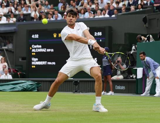 Spain s Carlos Alcaraz plays a backhand in his match against France s Ugo Humbert on day seven of the 2024 Wimbledon Championships in London on Sunday, July 07, 2024.  LON2024070720 HUGOxPHILPOTT