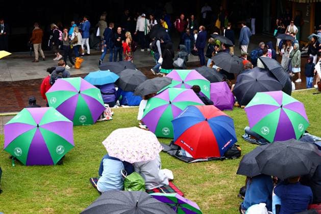 Spectators shelter under umbrellas around the grounds as rain falls before the start of play. Wimbledon Tennis Championships, Day 9, The All England Lawn Tennis and Croquet Club, London, UK - 09 Jul 2024  Copyright: xJamesxMarsh Shutterstockx 14577170h