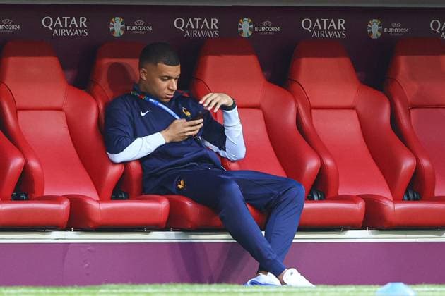 Kylian Mbappà of France sits on their phone in the dugout during the arrivals Spain v France, UEFA European Championship, EM, Europameisterschaft 2024, Semi Final, Football, Munich Football Arena, Munich, Germany - 09 Jul 2024 EDITORIAL USE ONLY No use with unauthorised audio, video, data, fixture lists, club league logos or live services. Online in-match use limited to 120 images, no video emulation. No use in betting, games or single club league player publications. Copyright: xKieranxMcManus Shutterstockx 14576874n
