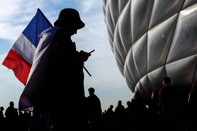 Spanien gegen Frankreich 9. Juli 2024, München UEFA EUROs Halbfinale Spanien gegen Frankreich Ein Frankreich-Fan ist vor der Allianz-Arena zu sehen, als er sein Handy überprüft, während er eine Fahne hält Foto Charlotte Wilson Abseits München Deutschland  Copyright: xCharlottexWilsonx xOffsidexOffside