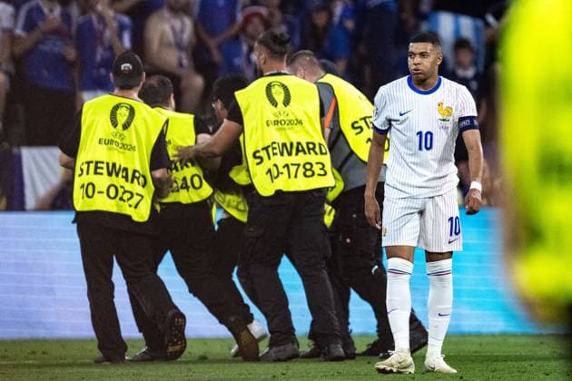 240709 Stewards take care of a pitch invader next to Kylian MbappÃ of France during the UEFA Euro 2024 Football Championship semifinal between Spain and France on July 9, 2024 in Munich Photo Mathias Bergeld BILDBYRAN code MB MB0944 fotboll football soccer fotballs em europamästerskap em uefa euro uefa european football championship euro 2024 semifinal semifinals spanien spain frankrike france bbeng  Copyright: MATHIASxBERGELD BB240709MB125