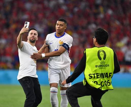 09 07 2024, Football UEFA EURO 2024, Semi-final, Spain France, at the Munich Football Arena A streaker with Kylian Mbappe France he takes a selfie