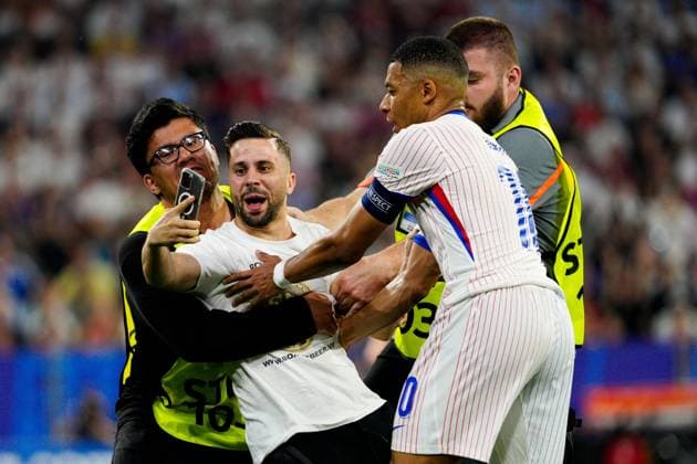 A pitch invader runs on the pitch for a selfie with Kylian Mbappà of France Spain v France, UEFA European Championship, EM, Europameisterschaft 2024, Semi Final, Football, Munich Football Arena, Munich, Germany - 09 Jul 2024 EDITORIAL USE ONLY No use with unauthorised audio, video, data, fixture lists, club league logos or live services. Online in-match use limited to 120 images, no video emulation. No use in betting, games or single club league player publications. Copyright: xDavexShopland Shutterstockx 14576888cu