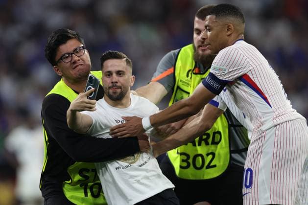 Munich , Germany 09.07.2024: fan invades the pitch to take a photograph with Kylian Mbappe of France during the UEFA EURO, EM, Europameisterschaft,Fussball 2024 semi-finals, football match between Spain vs France at Munich Football Allianz Arena  Copyright: xMarcoxIacobucci IPAxSportx xipa-x xx IPA_47861602 IPA_Agency_IPA47861602