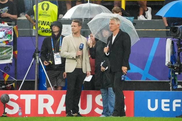 Presenters Alexander Bommes and Bastian Schweinsteiger under the umbrellas in the rain in Dortmund Dortmund 10 07 2024 Netherlands vs England, EURO2024 M50, semi-final, EM Arena Dortmund