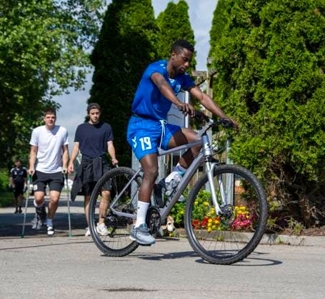 11 07 2024, Football 2 Bundesliga 2024 2025, 1 FC Magdeburg at the summer training camp in Bad Wörishofen in Unterallgäu, The team arrives at the training ground with bicycles, Lubambo Musonda Magdeburg