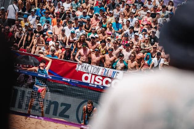 Beach volleyball men German Beach Tour 2024 Tourstop Munich 21 07 2024 Momme Lorenz serves in front of the fan group faction Bräune Munich Central University Sports Beach Bavaria Germany