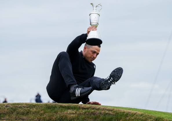 Champion Golfer Xander Schauffele holds the Claret Jug while sitting on top of a bunker at the 18th green at Royal Troon after winning The Open Championship 2024 with a score of 9 under par after 72 holes. The British Open Championship, Day Three, Golf, Royal Troon, Troon, UK - 21 July 2024  Copyright: xStuartxWallace Shutterstockx 14588006ci