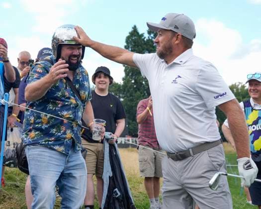 26th July 2024; JCB Golf &amp; Country Club, Rocester, Uttoxeter, England; LIV UK Golf League, Round 1; Graeme McDowell of the Smash GC interacts with a spectator wearing a glitter ball helmet after offering to down his pint if McDowell hit the first green during round one  ActionPlus12672195 StevenxFlynn