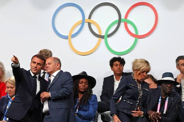Sport Themen der Woche KW30 Sport Bilder des Tages Nach seine Flucht von der unüberdachten Tribüne und aus dem Regen hält Bundeskanzler Olaf Scholz ein kurzes Gespräch mit Staatspräsident der Französischen Republik Emmanuel Macron, Französischer Staatspräsident, Dort gehts zum Olympiaerfolg, Gestik, Zeigen, Hindeuten, Eröffnungsfeier, Opening Ceremony, Ceremonie dÂ ouverture, Paris 2024, Olympic Games, Olympische Spiele, Olympia, OS Paris 2024, Olympic Games 2024, 26.07.2024, - *** After his escape from the uncovered grandstand and out of the rain, Federal Chancellor Olaf Scholz holds a short conversation with President of the French Republic Emmanuel Macron, French President, There it goes to the Olympic success, Gestures, Showing, Pointing, Opening Ceremony, Opening Ceremony, Ceremonie dÂ ouverture, Paris 2024, Olympic Games Paris 2024, Olympic Games 2024, 26 07 2024,