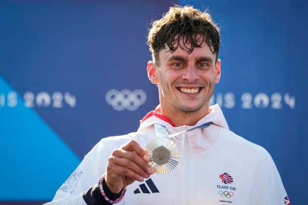 Adam Burgess of Team Great Britain smiles with his silver medal during the podium ceremony for the Men s C1 Canoe Slalom final at the Vaires-sur-Marne Nautical Stadium outside Paris during the 2024 Paris Summer Olympic Games, Olympische Spiele, Olympia, OS in Paris, France, Monday, July 29, 2024.  OLY20240729409 PaulxHanna