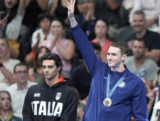 Bronze medalist Ryan Murphy of the U.S. (R) waves from the podium with gold medalist Thomas Ceccon of Italy after the Men s 100m Backstroke Finals at the Paris 2024 Olympics at the Arena Le Defense in Paris, France on Monday, July 29, 2024.  OLY202407291625 RICHARDxELLIS