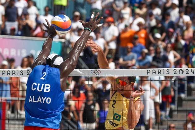 FRANCE, PARIS - JULY 30, 2024: Jorge Luis Alayo Moliner of Cuba (L) and Andre Loyola Stein of Brazil compete in a men s Pool D - Preliminary Phase Beach volleyball, Beachvolleyball match at the 2024 Summer Olympic Games, Olympische Spiele, Olympia, OS by the Eiffel Tower on the Champ de Mars.  72536641