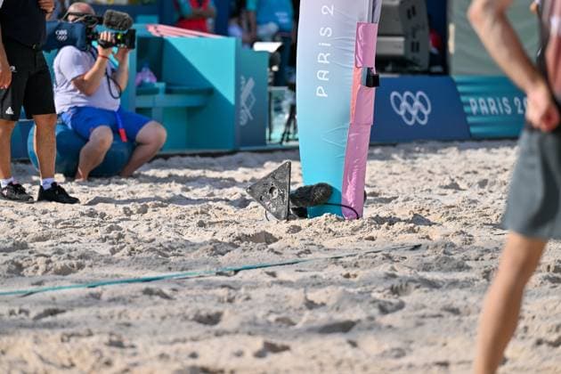 Olympic Games Beach Volleyball Paris 01 08 2024 Preliminary round, Men, GER AUS, Clemens Wickler trips over the microphone, which is set up on the net post, towards the court Wickler then pulls it out of the sand and throws it backwards Copyright: xBEAUTIFULxSPORTS TomxBlochx