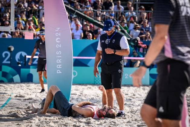 01 08 2024, Paris, Eiffel Tower Stadium Beach volleyball, Olympic Games, preliminary round Clemens Wickler GER trips over net camera and injures referee Giovanni Bake RSA with him