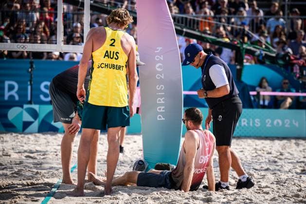 01 08 2024, Paris, Eiffel Tower Stadium Beach volleyball, Olympic Games, preliminary round Clemens Wickler GER trips over net camera and injures himself Zachery Schubert AUS , Nils Ehlers GER and referee Giovanni Bake RSA with him