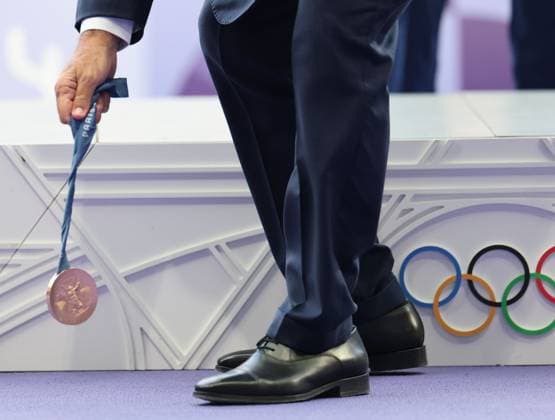 (240807) -- PARIS, Aug. 7, 2024 -- The bronze medal falls down during the victory ceremony of the men s long jump of Athletics at the Paris 2024 Olympic Games, Olympische Spiele, Olympia, OS in Paris, France, Aug. 7, 2024. ) (PARIS2024) FRANCE-PARIS-OLY-ATHLETICS-LONG JUMP-MEN LixGang 