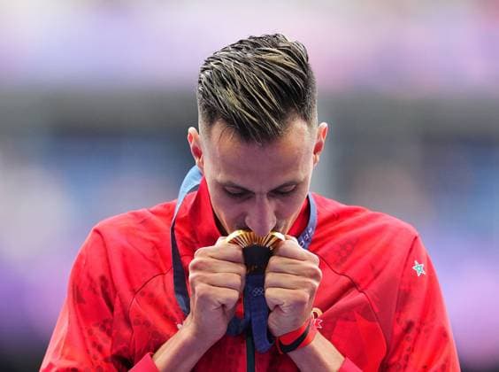(240808) -- PARIS, Aug. 8, 2024 -- Gold medalist Soufiane El Bakkali of Morocco kisses his gold medal during the victory ceremony of the men s 3000m steeplechase of Athletics at the Paris 2024 Olympic Games, Olympische Spiele, Olympia, OS in Paris, France, Aug. 8, 2024. ) (PARIS2024) FRANCE-PARIS-OLY-ATHLETICS-3000M STEEPLECHASE-MEN XuxChang 