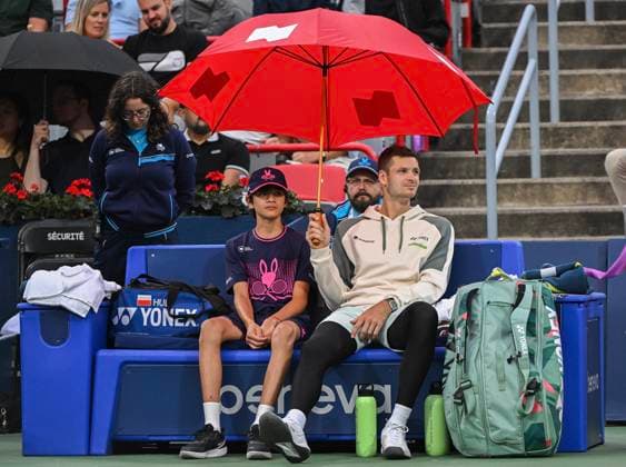 August 8, 2024, Montreal, Pq, Canada: Hubert Hurkacz of Poland holds an umbrella next to a ball boy during a rain stoppage ahead of his second round match against Thanasi Kokkinakis of Australia at the National Bank Open tennis tournament in Montreal, Thursday, August 8, 2024. Hubert Hurkacz, Thanasi Kokkinakis,  - ZUMAc35_ 20240808_zaf_c35_160 Copyright: xGrahamxHughesx