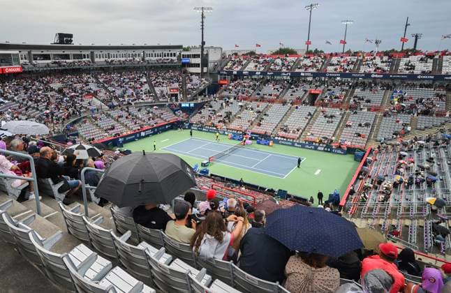 August 8, 2024, Montreal, Pq, Canada: People sit with umbrellas on centre court during a rain stoppage ahead of the second round match between Thanasi Kokkinakis of Australia and Hubert Hurkacz of Poland at the National Bank Open tennis tournament in Montreal, Thursday, August 8, 2024. National Bank Tennis,  - ZUMAc35_ 20240808_zaf_c35_162 Copyright: xGrahamxHughesx