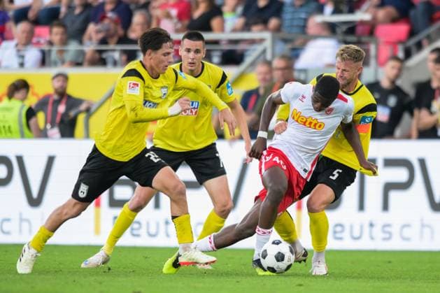 Soccer, 2 Bundesliga, 20240809, SSV Jahn Regensburg SSV Ulm 1846 In the picture Max BRANDT SSV Ulm 1846, 23 , Bastian ALLGEIER SSV Ulm 1846, 7 , Mansour OURO TAGBA SSV Jahn Regensubrg, 40 Dribbling ball and Johannes REICHERT SSV Ulm 1846, 5 Regensburg Jahnstadion Bayern Germany Copyright: Passion2Press MarkusxFischerx