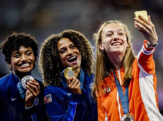 PARIS - Femke Bol takes a selfie with her bronze medal together with Anna Cockrell (L, silver) and Sydney McLaughlin-Levrone (M, gold) during the medal ceremony of the Olympic athletics competitions. ANP REMKO DE WAAL xVIxANPxSportx xxANPxIVx 505611280 originalFilename: 505611280.jpg