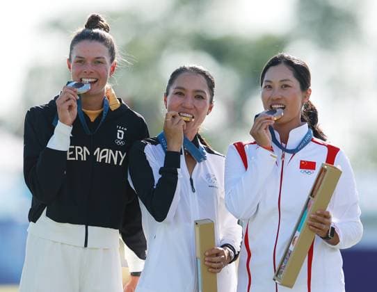 (240810) -- SAINT-QUENTIN-EN-YVELINES, Aug. 10, 2024 -- Gold medalist Lydia Ko (C) of New Zealand, silver medalist Esther Henseleit (L) of Germany and bronze medalist Lin Xiyu of China bite their medals during the victory ceremony for the women s golf individual stroke play at the Paris 2024 Olympic Games, Olympische Spiele, Olympia, OS in Saint-Quentin-en-Yvelines, France, Aug. 10, 2024. ) (PARIS2024) FRANCE-SAINT-QUENTIN-EN-YVELINES-OLY-GOLF RenxZhenglai 