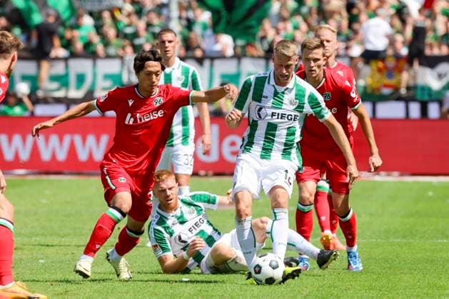 Sei Muroya Hannover 96 and Marc Lorenz SC Preussen Muenster fight for the ball, 2 Bundesliga, Preußen Münster vs Hannover 96, Preußenstadion, 11 08 2024, Münster, Germany