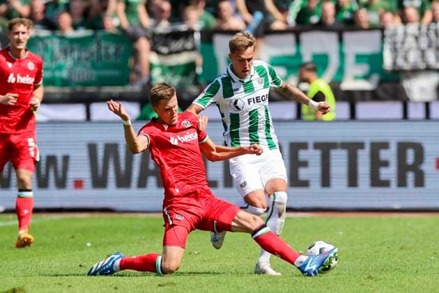 Fabian Kunze Hannover 96 and Joel Grodowski SC Preussen Muenster fight for the ball, 2 Bundesliga, Preußen Münster vs Hannover 96, Preußenstadion, 11 08 2024, Münster, Germany