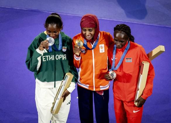 PARIS - Sifan Hassan with her gold medal, together with Tigst Assefa (silver) and Hellen Obiri (bronze) on the podium during the closing ceremony of the Summer Olympics in Stade de France. ANP KOEN VAN WEEL xVIxANPxSportx xxANPxIVx 505825090 originalFilename: 505825090.jpg