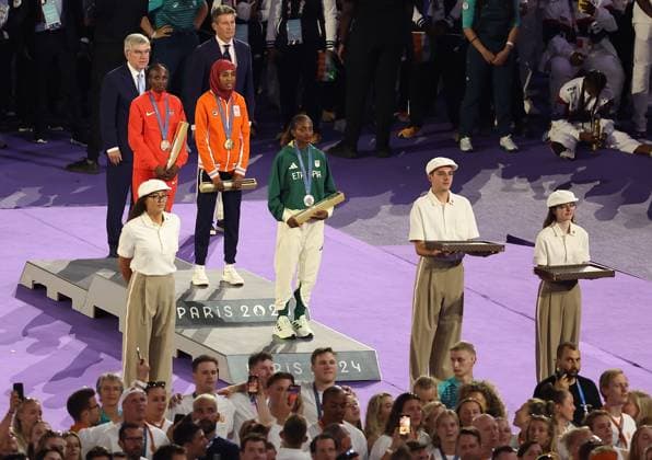 (240811) -- PARIS, Aug. 11, 2024 -- Gold medalist Sifan Hassan (C) of the Netherlands, silver medalist Tigst Assefa (front) of Ethiopia and bronze medalist Hellen Obiri of Kenya attend the victory ceremony of women s marathon of Athletics at the closing ceremony of the Paris 2024 Olympic Games, Olympische Spiele, Olympia, OS in Paris, France, Aug. 11, 2024. ) (PARIS2024) FRANCE-PARIS-OLY-CLOSING CEREMONY ZhangxFan 