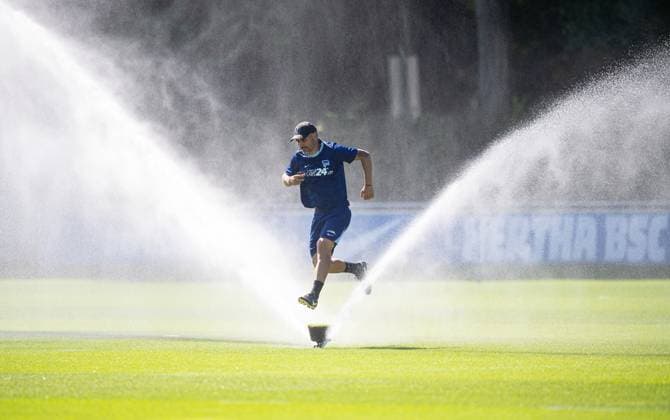 Soccer, Men, Season 2024 25, 2 Bundesliga, Hertha BSC, Training, Coach Cristian Fiel Hertha BSC jumps over a sprinkler, 13 08 2024, Copyright: xSebastianxRäppold MatthiasxKochx