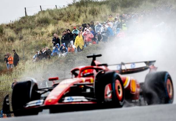 ZANDVOORT - Audience in the rain watches Charles Leclerc (Ferrari) in action during the 1st free practice in the run-up to the F1 Grand Prix of the Netherlands at the Circuit of Zandvoort. ANP REMKO DE WAAL xVIxANPxSportx xxANPxIVx 506554821 originalFilename: 506554821.jpg