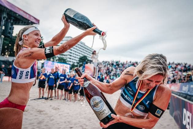 Beach volleyball women and men Allianz German Beach Tour German Beach Volleyball Championship 2024 01 09 2024 f l Sandra Ittlinger and Laura Ludwig Beer shower Timmendorfer Strand Ahmann Hager Arena Schleswig Holstein Germany