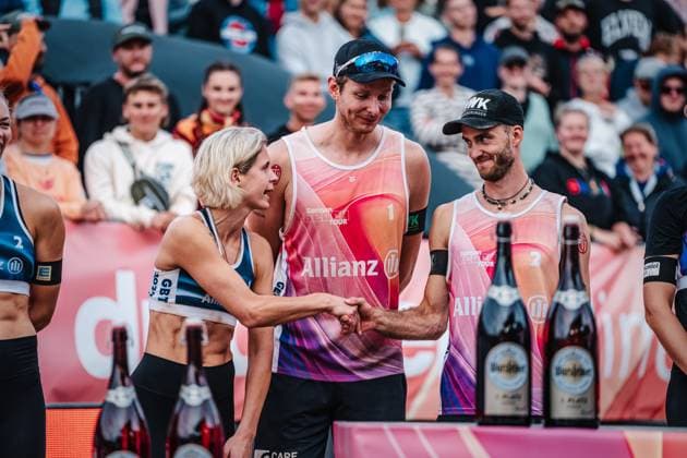 Beach volleyball women and men Allianz German Beach Tour German Beach Volleyball Championship 2024 01 09 2024 left Laura Ludwig and right Clemens Wickler shake hands, in the middle Nils Ehlers Timmendorfer Strand Ahmann Hager Arena Schleswig Holstein Germany