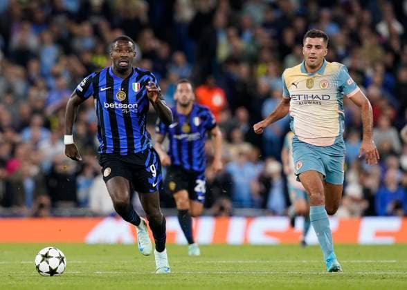Manchester, England, 18th September 2024. Marcus Thuram of Inter Milan breaks clear of Rodri of Manchester City during the UEFA Champions League match at the Etihad Stadium, Manchester. Picture credit should read: Andrew Yates Sportimage EDITORIAL USE ONLY. No use with unauthorised audio, video, data, fixture lists, club league logos or live services. Online in-match use limited to 120 images, no video emulation. No use in betting, games or single club league player publications. SPI-3321-0033
