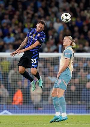 Manchester, England, 18th September 2024. Hakan Calhanoglu of Inter Milan jumps in front of Erling Haaland of Manchester City during the UEFA Champions League match at the Etihad Stadium, Manchester. Picture credit should read: Andrew Yates Sportimage EDITORIAL USE ONLY. No use with unauthorised audio, video, data, fixture lists, club league logos or live services. Online in-match use limited to 120 images, no video emulation. No use in betting, games or single club league player publications. SPI-3321-0040