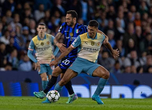 (240919) -- MANCHESTER, Sept. 19, 2024 -- Manchester City s Rodri (R) is challenged by Inter Milan s Hakan Calhanoglu during the UEFA Champions League match between Manchester City and Inter Milan in Manchester, Britain, on Sept. 18, 2024. (SP)BRITAIN-MANCHESTER-FOOTBALL-UEFA CHAMPIONS LEAGUE-MANCHESTER CITY VS INTER MILAN LixYing 