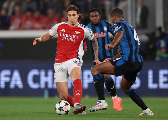 Bergamo, Italy, 19th September 2024. Riccardo Calafiori of Arsenal FC passes the ball as Isak Hien of Atalanta closes in during the UEFA Champions League match at Gewiss Stadium, Bergamo. Picture credit should read: Jonathan Moscrop Sportimage EDITORIAL USE ONLY. No use with unauthorised audio, video, data, fixture lists, club league logos or live services. Online in-match use limited to 120 images, no video emulation. No use in betting, games or single club league player publications. SPI-3299-0031