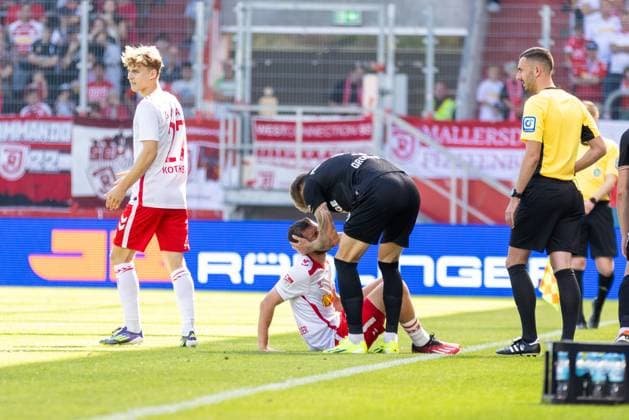 22 09 2024, Soccer, GER, Season, 2 Liga, Season 2024 2025, Matchday 6, SSV Jahn Regensburg SC Preußen Münster Joel Grodowski apologizes to Oscar Schönfelder SSV Jahn Regensburg after the foul DFL REGULATIONS PROHIBIT ANY USE OF PHOTOGRAPHS AS IMAGE SEQUENCES AND OR QUASI VIDEO Regensburg Bayern Germany Jahnstadion Regensburg