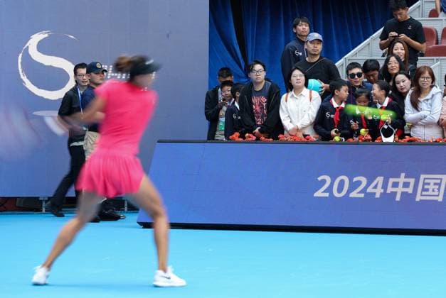 (240923) -- BEIJING, Sept. 23, 2024 -- Spectators watch Zheng Qinwen (front) of China attending a training session at 2024 China Open tennis tournament in Beijing, capital of China, Sept. 23, 2024. ) (SP)CHINA-BEIJING-TENNIS-CHINA OPEN-TRAINING (CN) BaixXuefei 